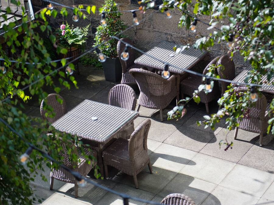 An outdoor patio with wicker furniture and string lights.