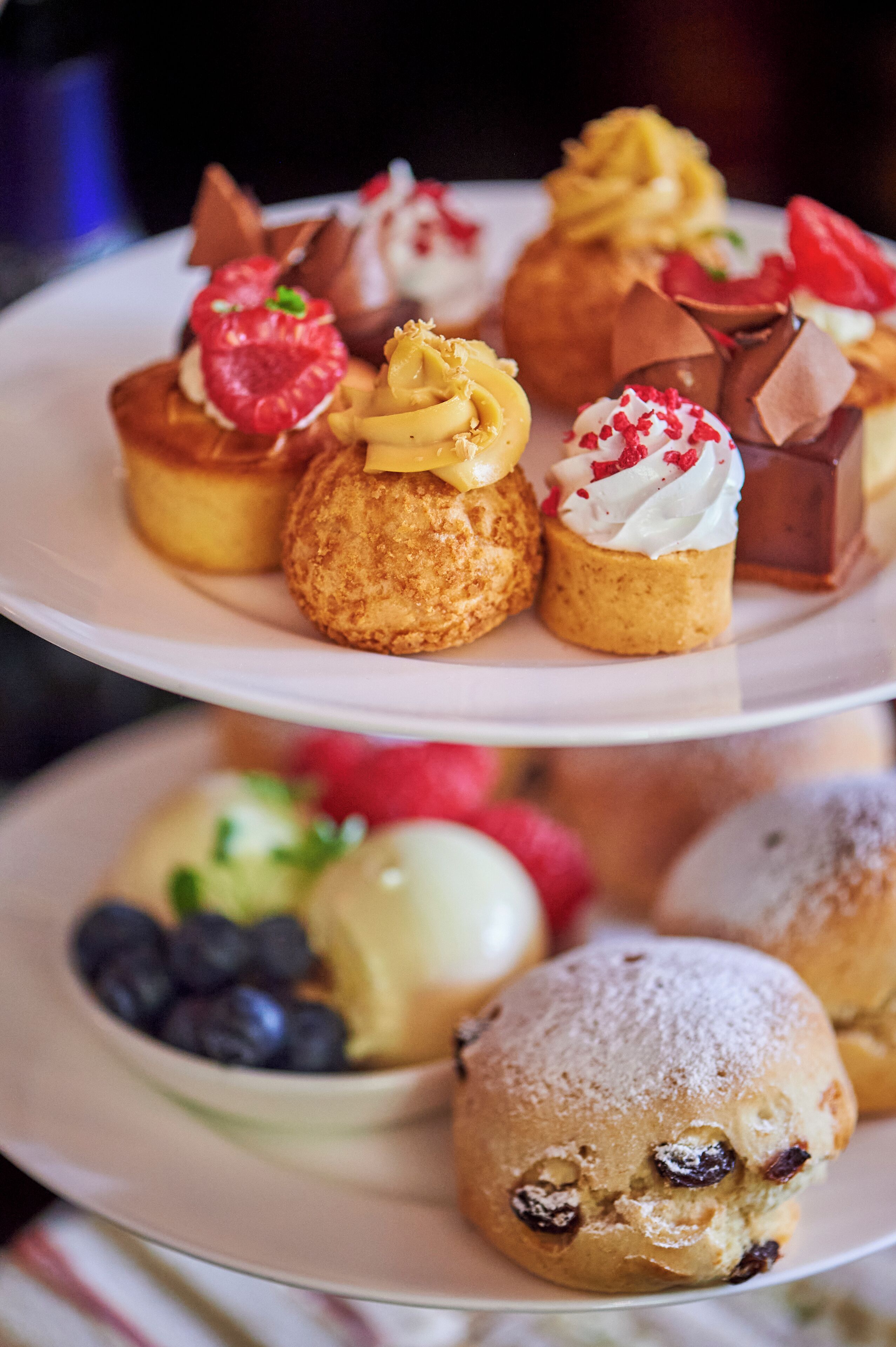 Een verhoogd bord met diverse gebakjes en desserts.