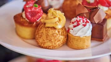 Een verhoogd bord met diverse gebakjes en desserts.