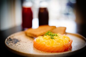 A plate with salmon and mashed potatoes garnished with herbs.