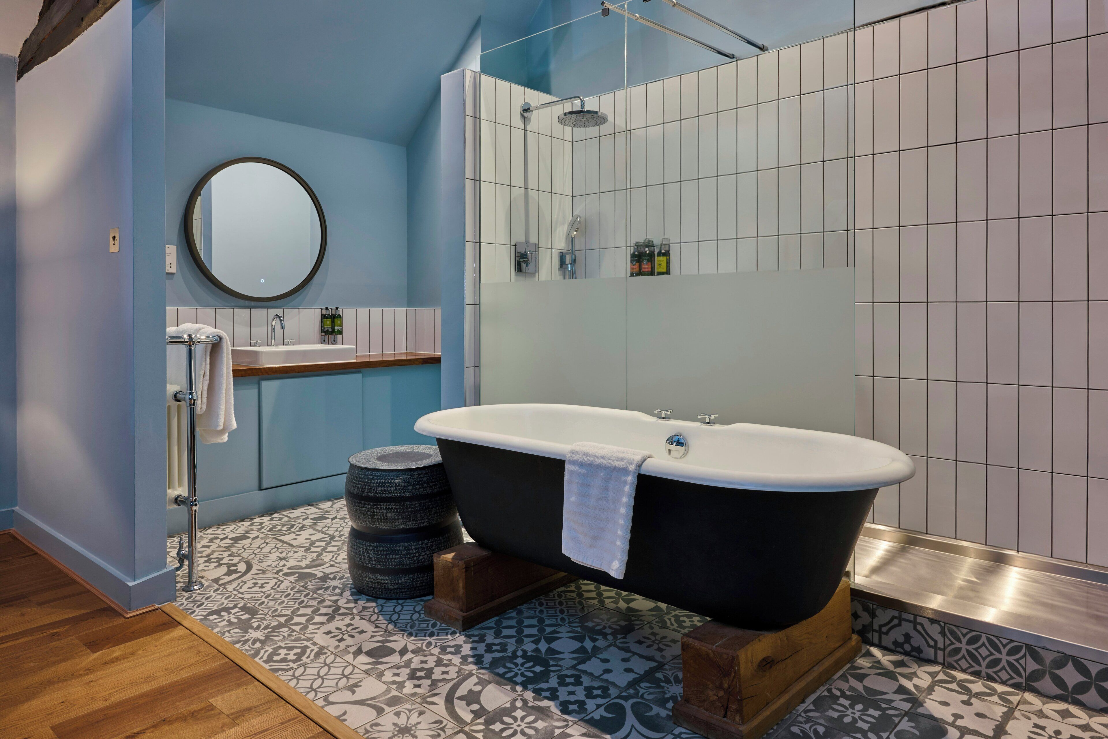 A modern bathroom with a freestanding bathtub, a shower, and a vanity with a mirror.