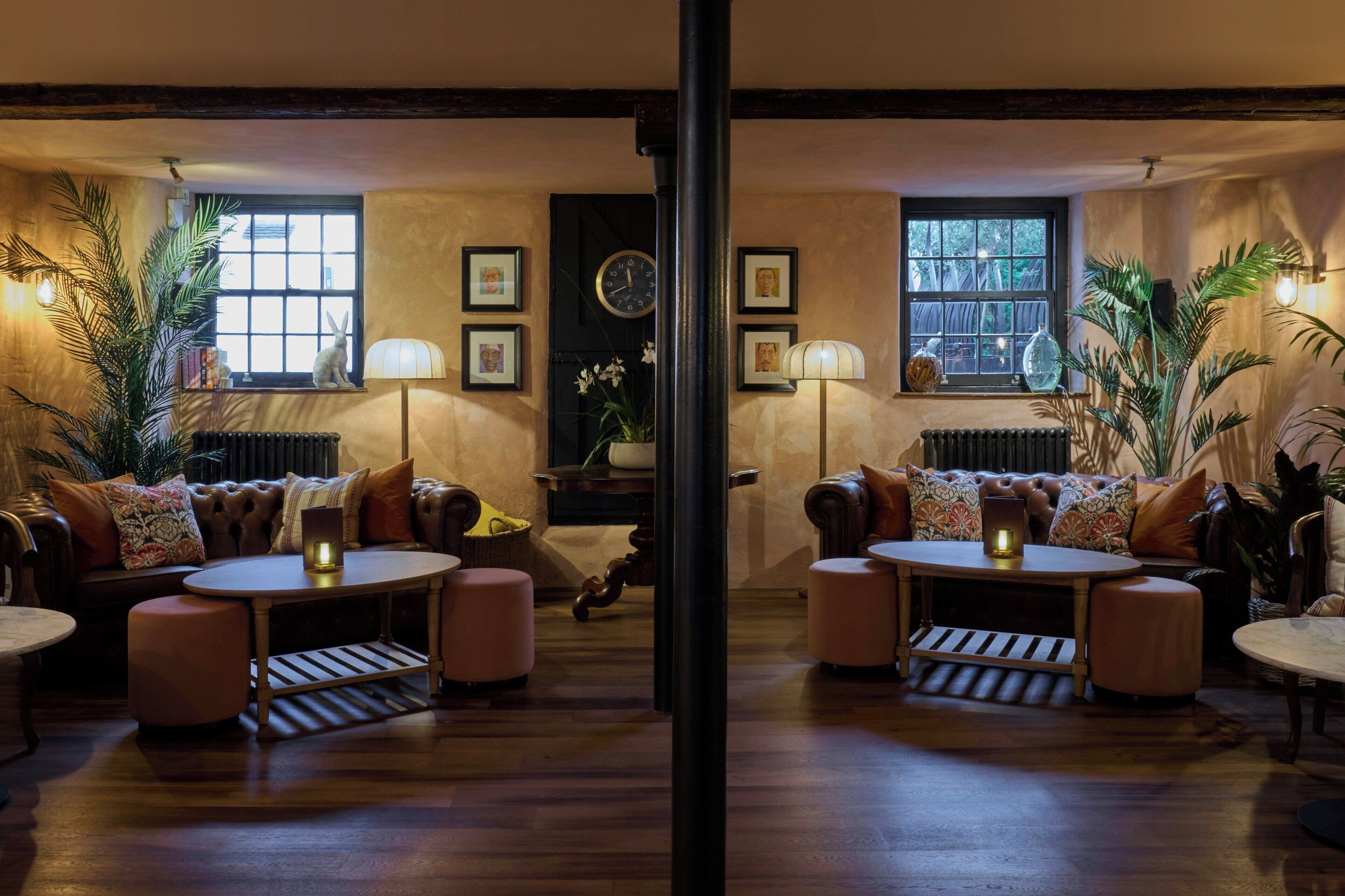 A cozy room with a fireplace, leather sofas, and a large window with a view.