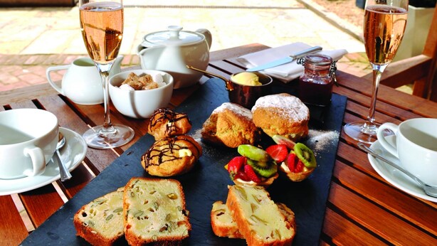 An outdoor dining area with a table set for a meal, including bread, pastries, and drinks. - Hotel du Vin & Bistro Poole (Poole)