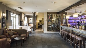 A bar area with stools, a counter, and a wine rack. - Hotel du Vin & Bistro Poole (Poole)