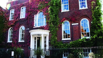 Stunning historic building with a classic facade, adorned with lush vines and a charming entrance.