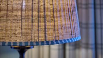 A close-up of a lamp with a textured fabric shade.