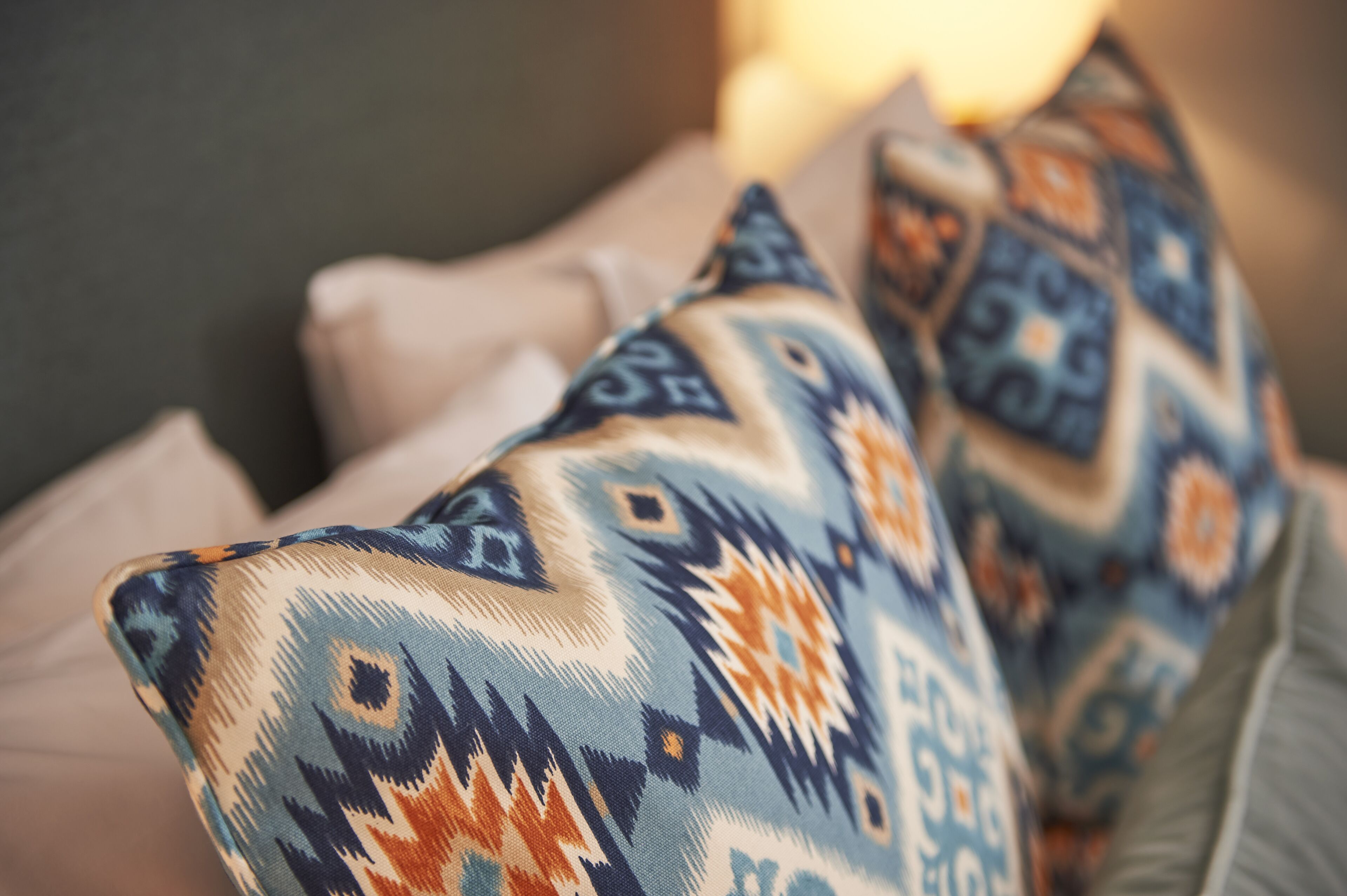 Un gros plan d’un coussin à motifs posé sur un canapé.
