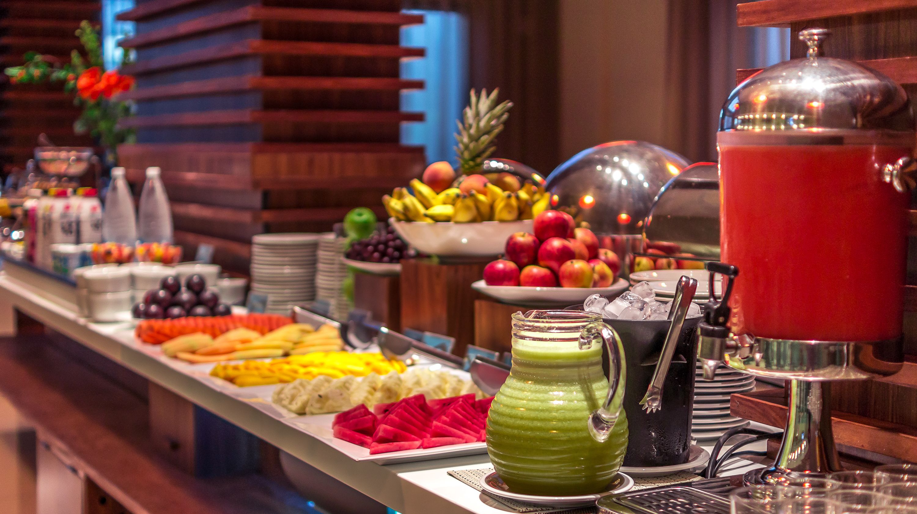 Un bufé con frutas, verduras y bebidas diversas.