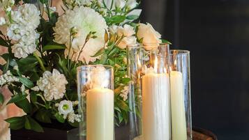 Un barril de madera rústico con un arreglo floral y velas.