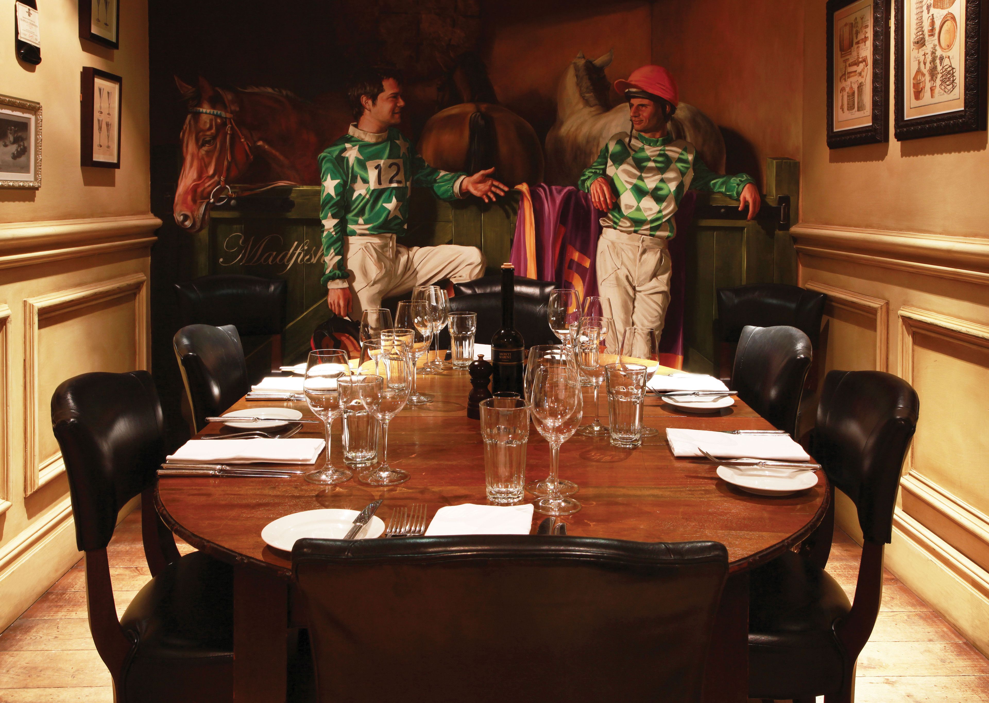 A formal dining room with a long table set for a meal, surrounded by leather chairs.