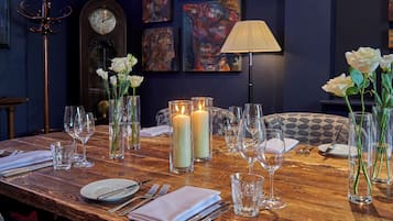 A dining table set with candles, glasses, and white flowers.