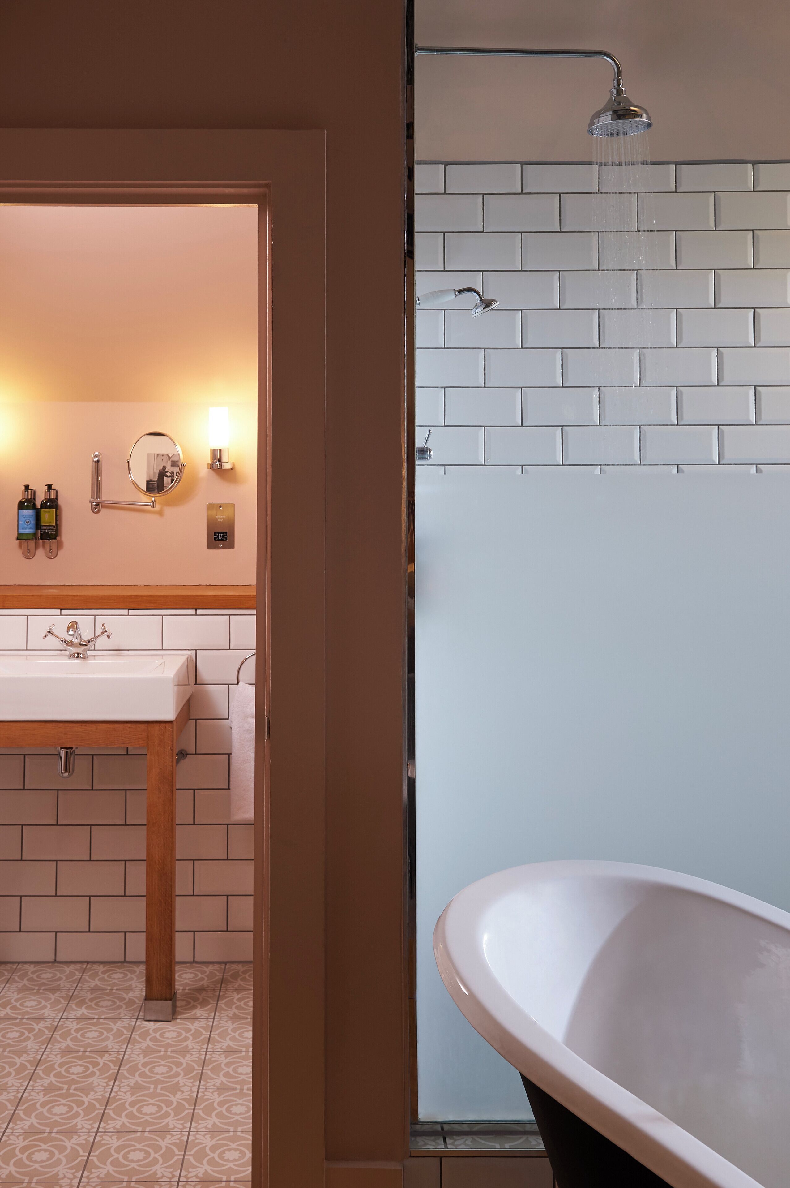 A bathroom with a white sink, mirror, and a freestanding bathtub.