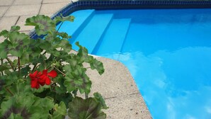 Una piscina con agua azul cristalina y escalones para entrar.
