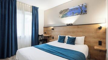 Une chambre d’hôtel avec un grand lit, un bureau et un tableau au mur.