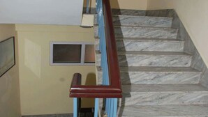Una scala con gradini in marmo e una ringhiera in legno.