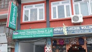 Un edificio con insegne per 'Hotel Travelers Home P. Ltd.' e 'Himalaya Classical Wollen'.