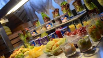 Un bufé con diversas frutas y bebidas.