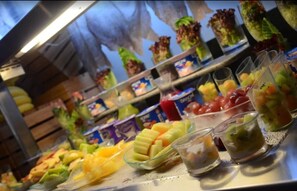 Buffet com diversas frutas e bebidas.