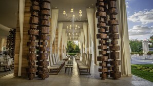 A spacious indoor area with wooden columns, rows of chairs, and tables, suggesting a dining or meeting area. - Platinum Yucatan Princess Adults Only - All Inclusive  (Playa del Carmen)