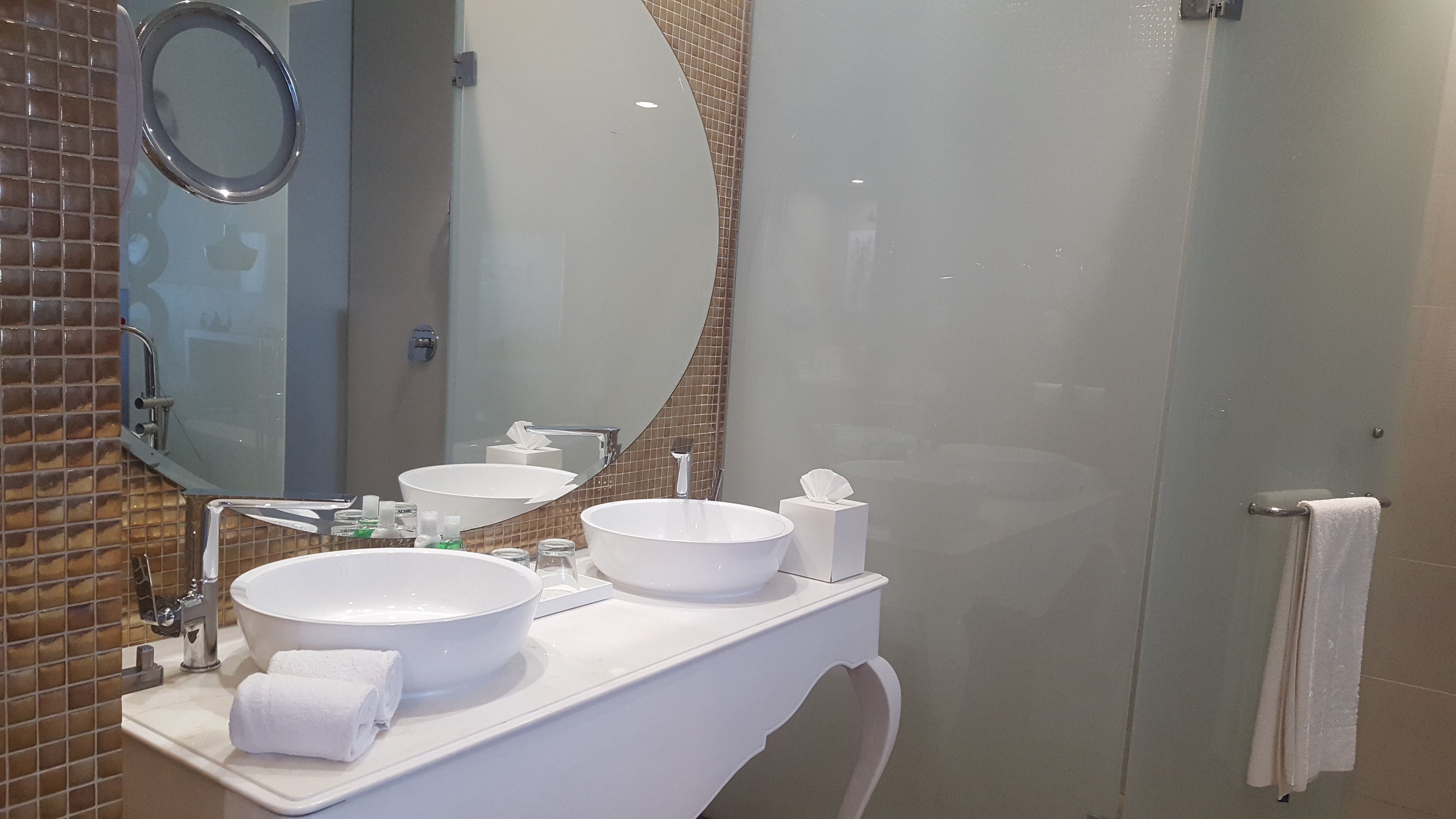 Un baño con dos lavamanos, un espejo y una zona de ducha.