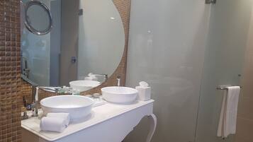 Un baño con dos lavamanos, un espejo y una zona de ducha.