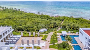 A resort with a swimming pool, lounge area, and a view of the ocean. - Platinum Yucatan Princess Adults Only - All Inclusive  (Playa del Carmen)