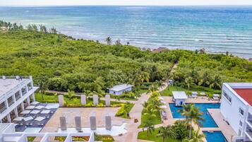 Relax by the ocean with a serene garden and pool area, perfect for unwinding.