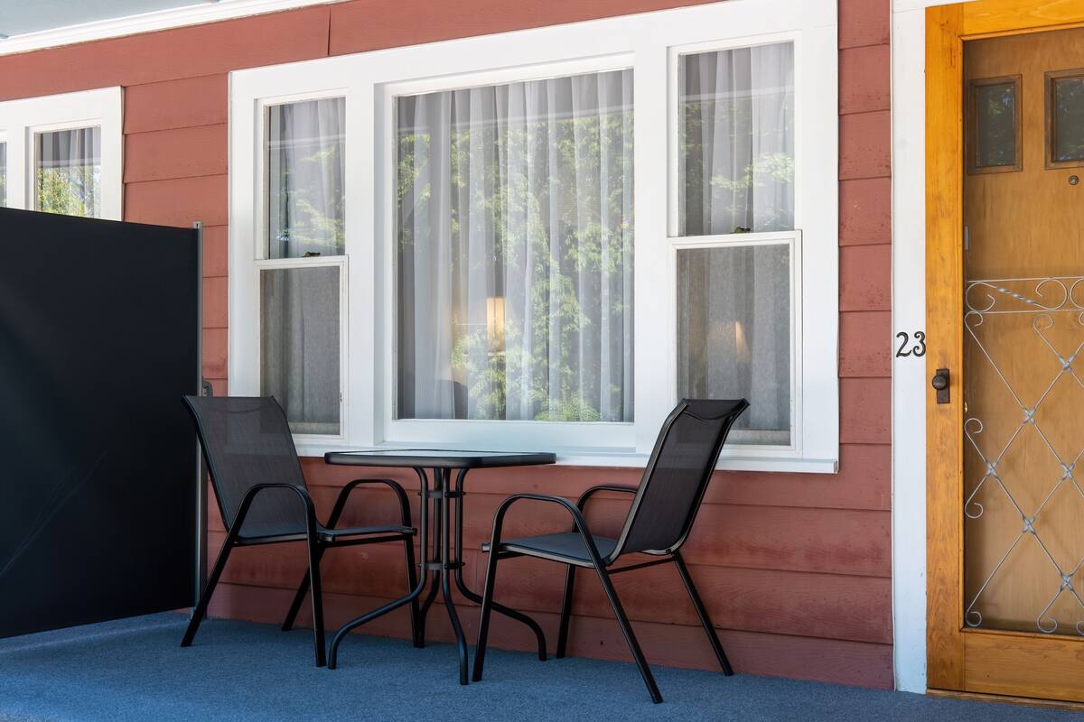 A room with a window, a door, and a table with chairs.