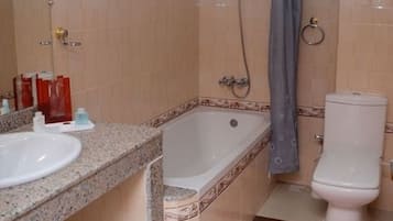 Un baño con lavamanos, bañera e inodoro.