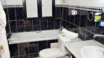A bathroom with a bathtub, toilet, and sink.