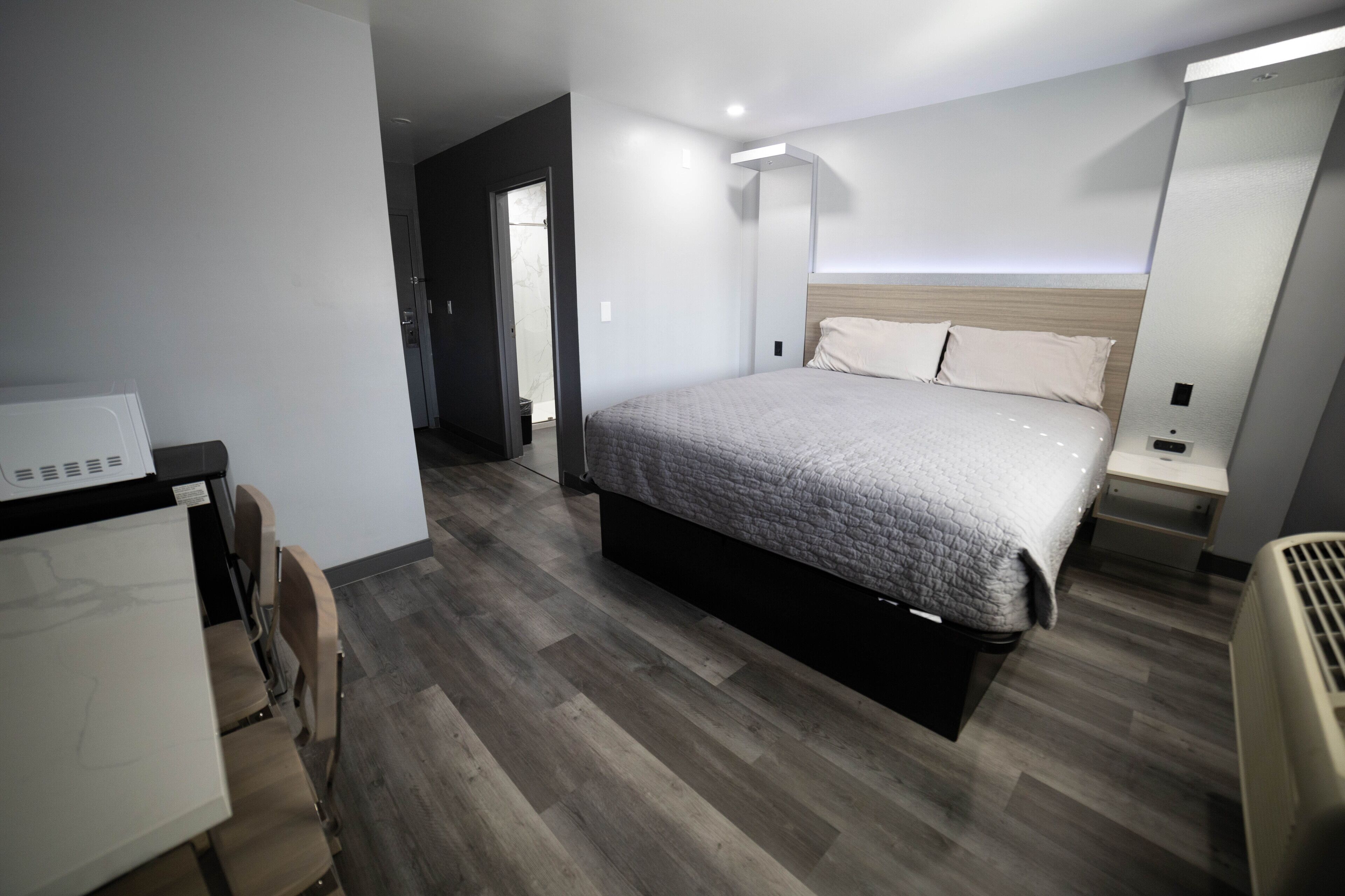 Une chambre d’hôtel moderne, dotée d’un grand lit, d’un bureau et d’une chaise.