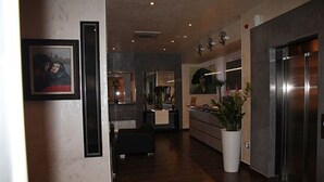 A modern hotel lobby with a reception desk, a large potted plant, and a refrigerator. - ABC Hotel (Algiers)
