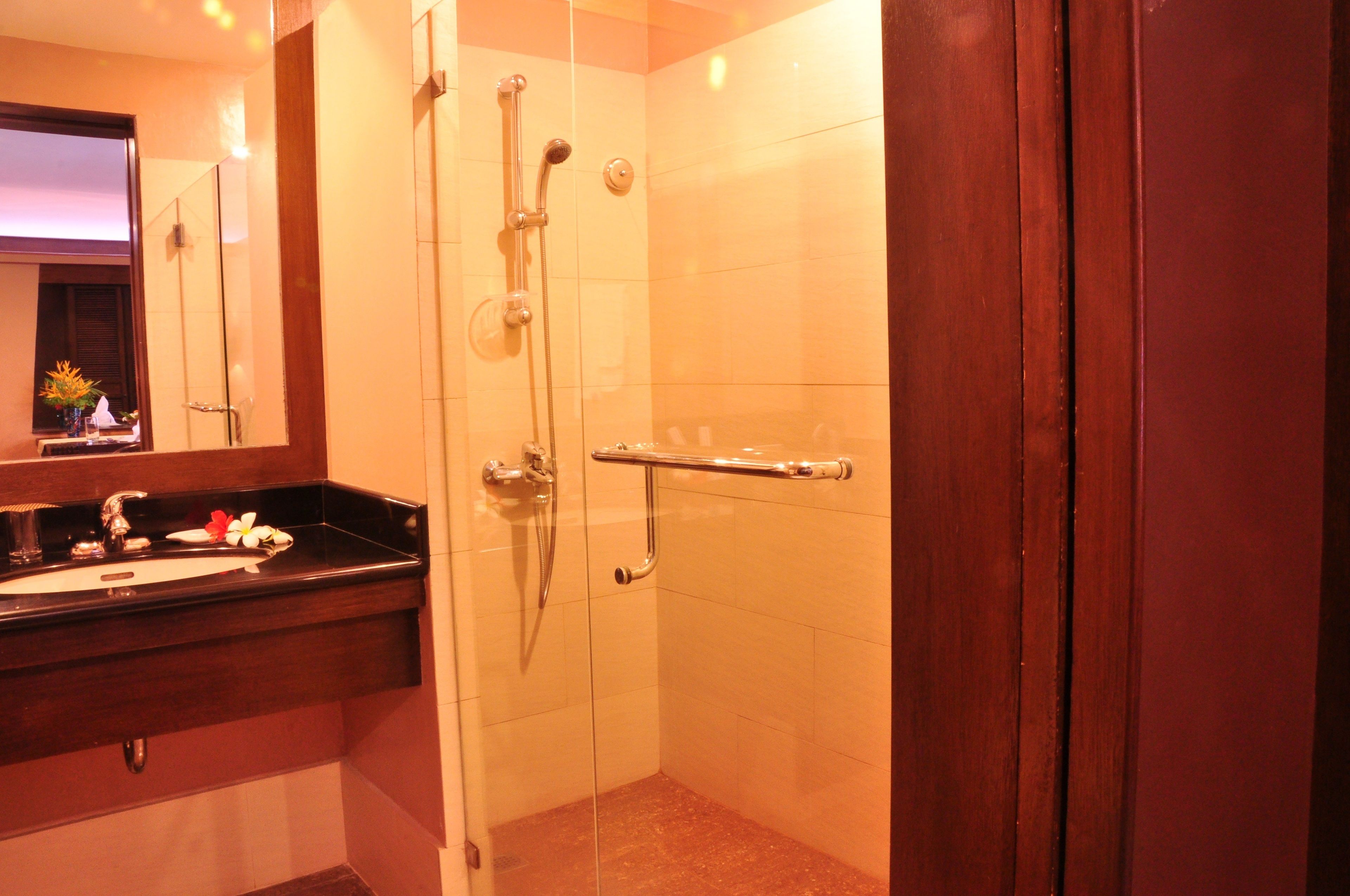 Une salle de bain avec une douche à parois de verre, un meuble-lavabo et un miroir.