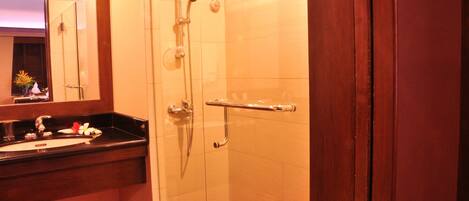 Une salle de bain avec une douche à parois de verre, un meuble-lavabo et un miroir.