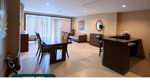 A modern living area with a dining table, chairs, a sofa, a coffee table, and a kitchen counter. - Coralpoint Gardens (Lapu-Lapu)
