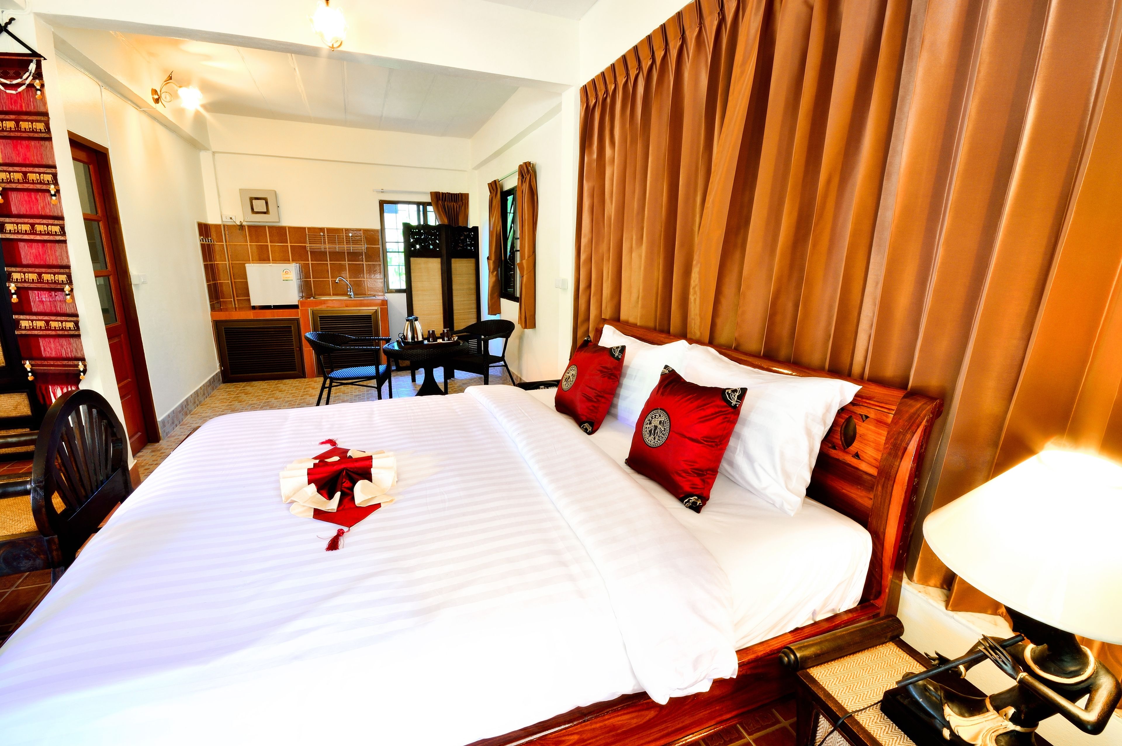 A hotel room with a bed, a desk, a chair, and a bathroom visible in the background.