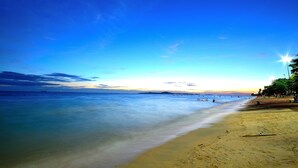 A beach with clear water, a sandy shore, and a distant shoreline. - Avila Resort (Pattaya)