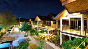 A row of modern, multi-story buildings with balconies and outdoor seating areas, connected by a covered walkway. - Avila Resort (Pattaya)