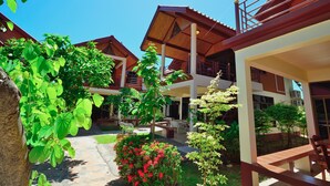 A courtyard with a covered seating area, a staircase, and a view of the surrounding buildings. - Avila Resort (Pattaya)
