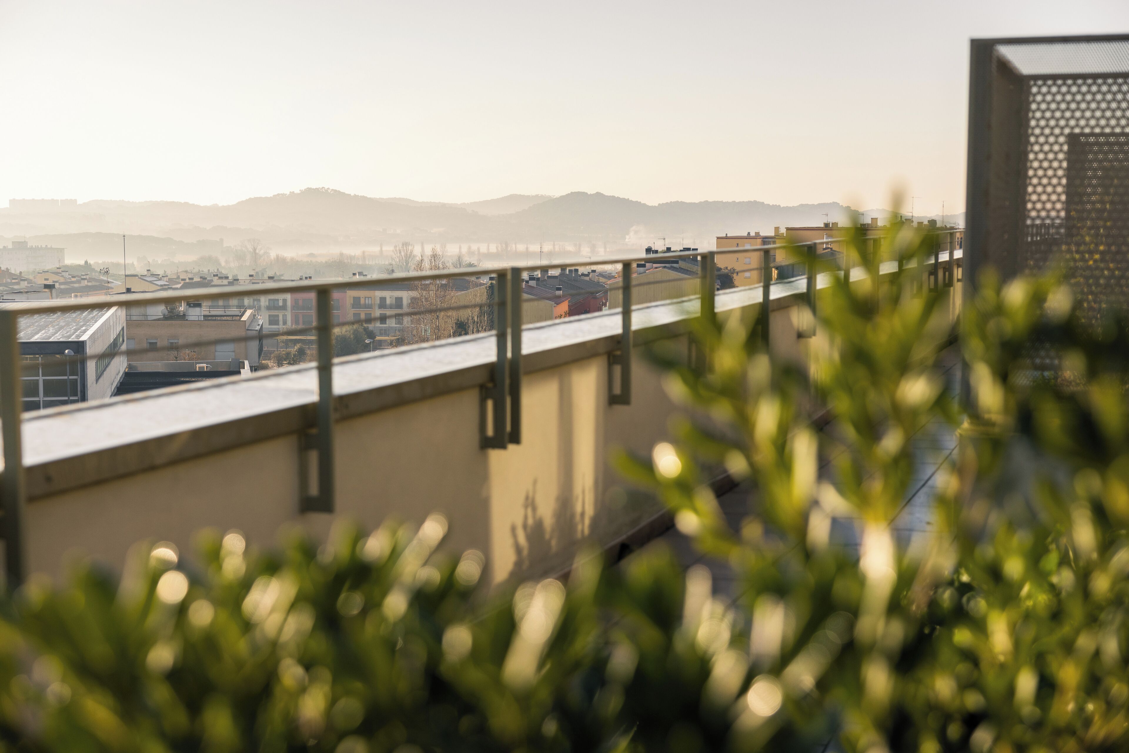 Eine Dachterrasse mit Blick auf entfernte Gebäude und Hügel.