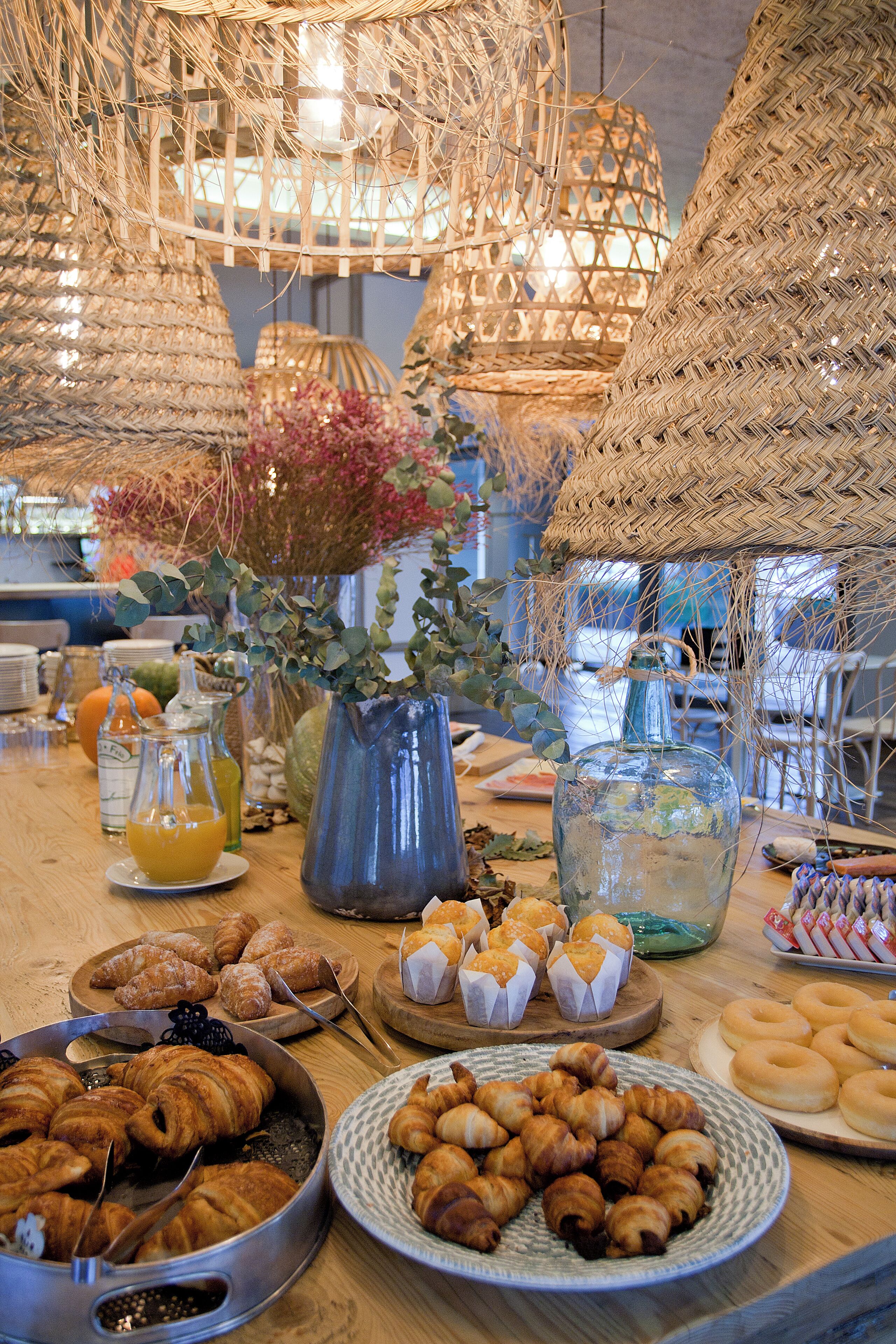 A buffet table with various food items, including pastries and drinks.