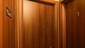 Eine Holztür mit einem Schild, auf dem 'Toilette' steht.