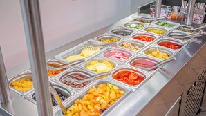 Ein Buffet mit verschiedenen Speisen in separaten Behältern.