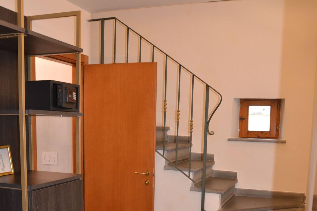 A staircase with a wooden door and metal railings leading to an upper floor.