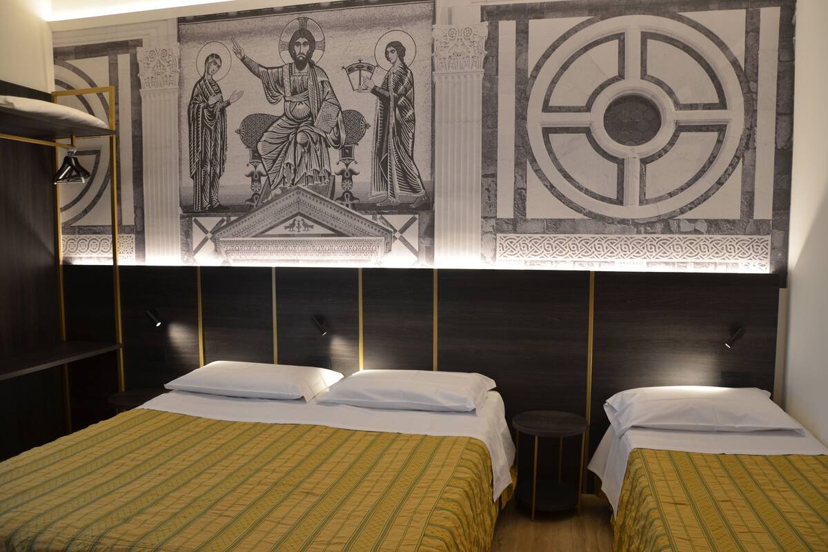 A hotel room with two beds, a large wall mural, and a modern design.