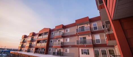 Un edificio residencial de varios pisos con balcones y ventanas amplias.