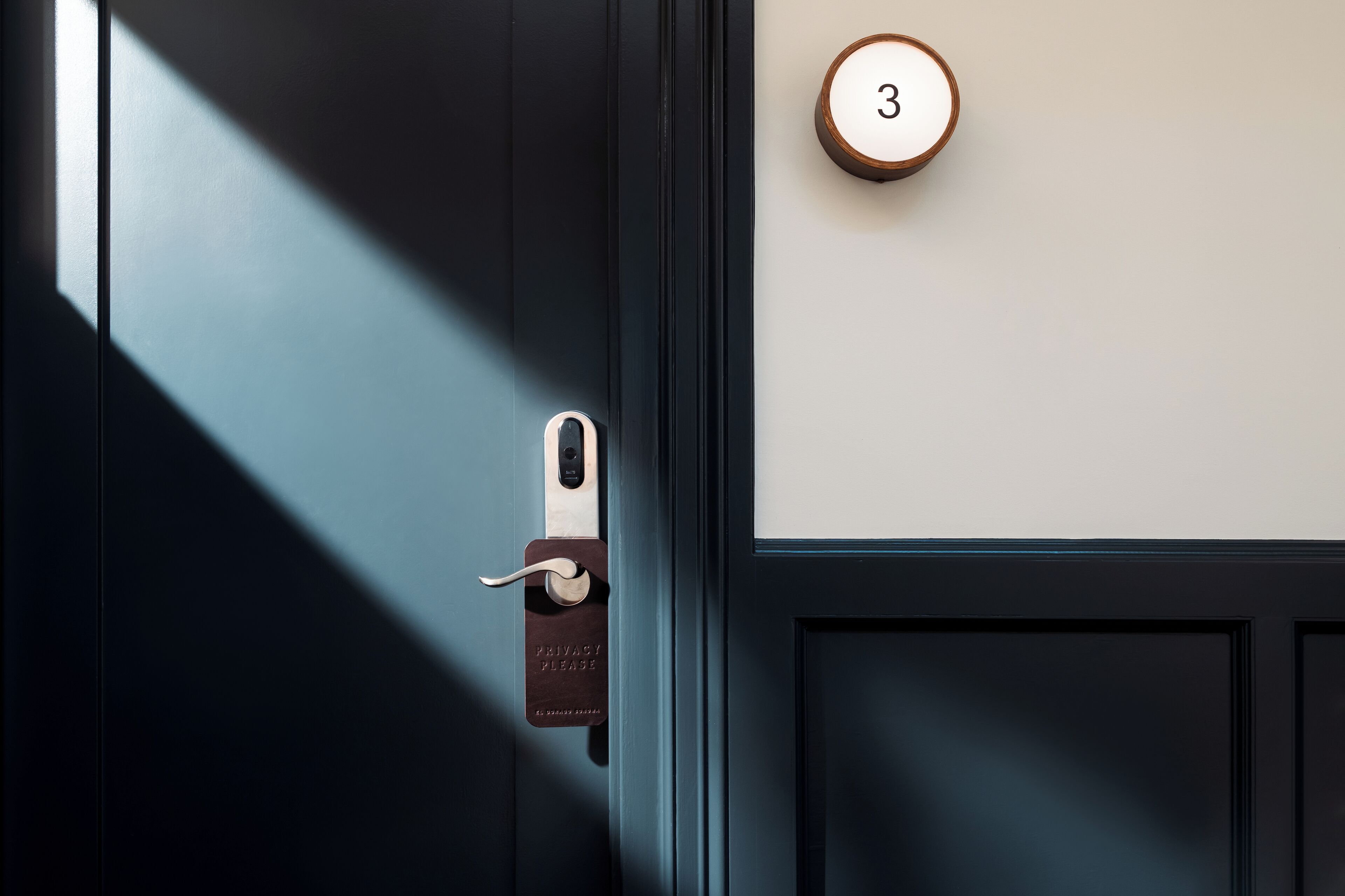 Una puerta con un cerrojo de seguridad y una placa con el número de habitación.