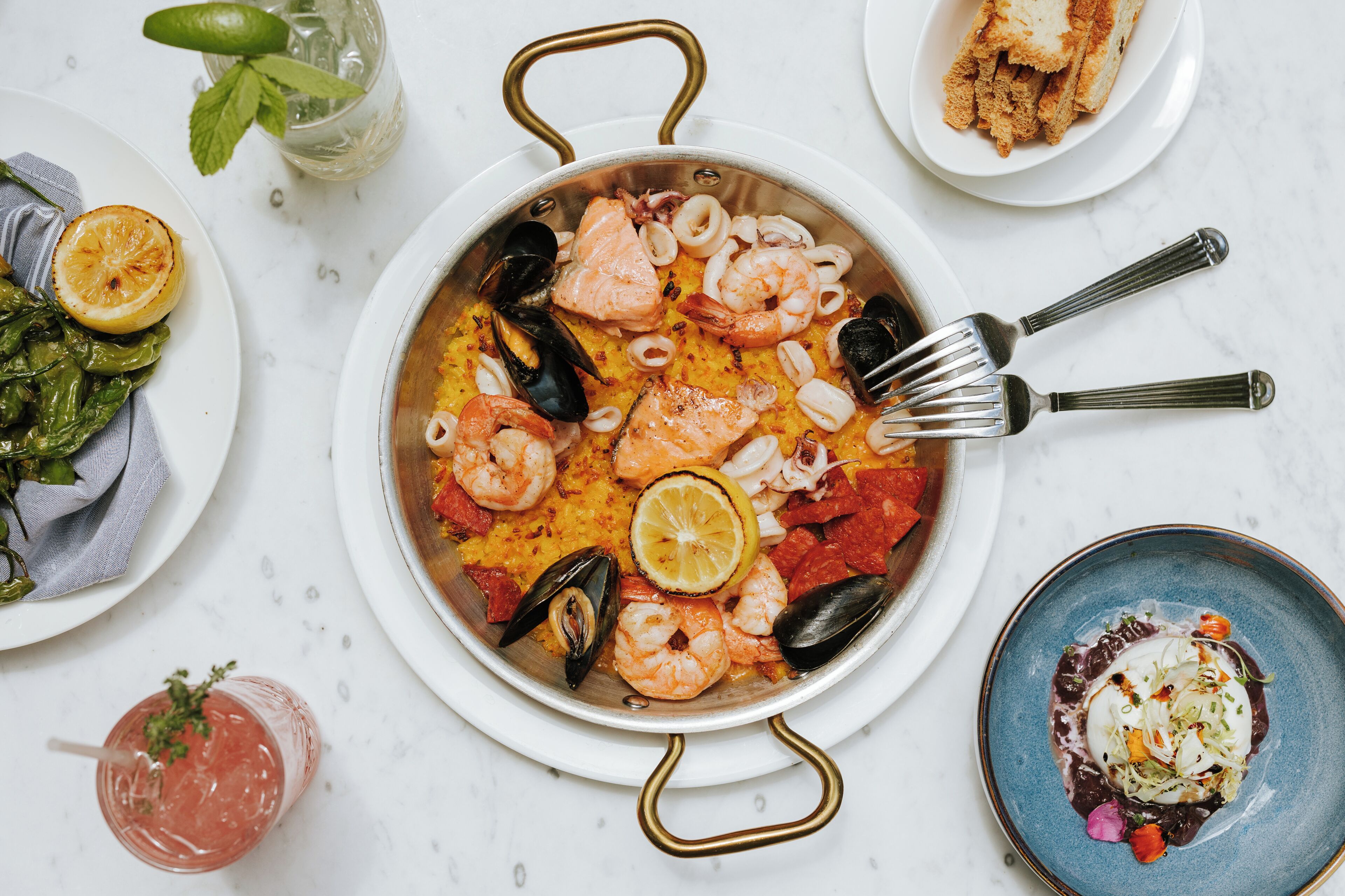 A seafood dish with shrimp, mussels, and lemon slices on a white plate.