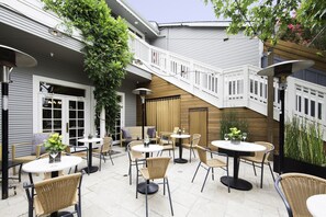 A patio area with outdoor seating, a staircase, and a view of a garden. - El Dorado Hotel (Sonoma)