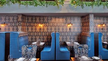 A restaurant with blue booths and patterned wallpaper.